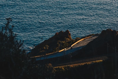 辆黑色轿车在道路附近的水域在白天
